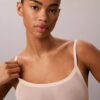 Minimalistisk bodysuit i mesh som slutar vid mitten av låret Minimalistisk bodysuit i mesh som slutar vid mitten av låret