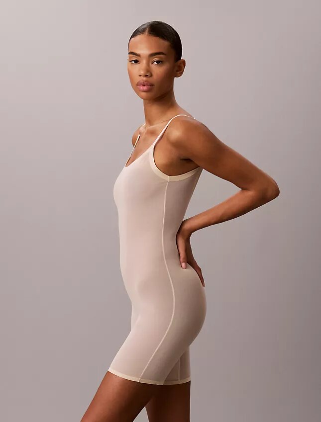 Minimalistisk bodysuit i mesh som slutar vid mitten av låret Minimalistisk bodysuit i mesh som slutar vid mitten av låret